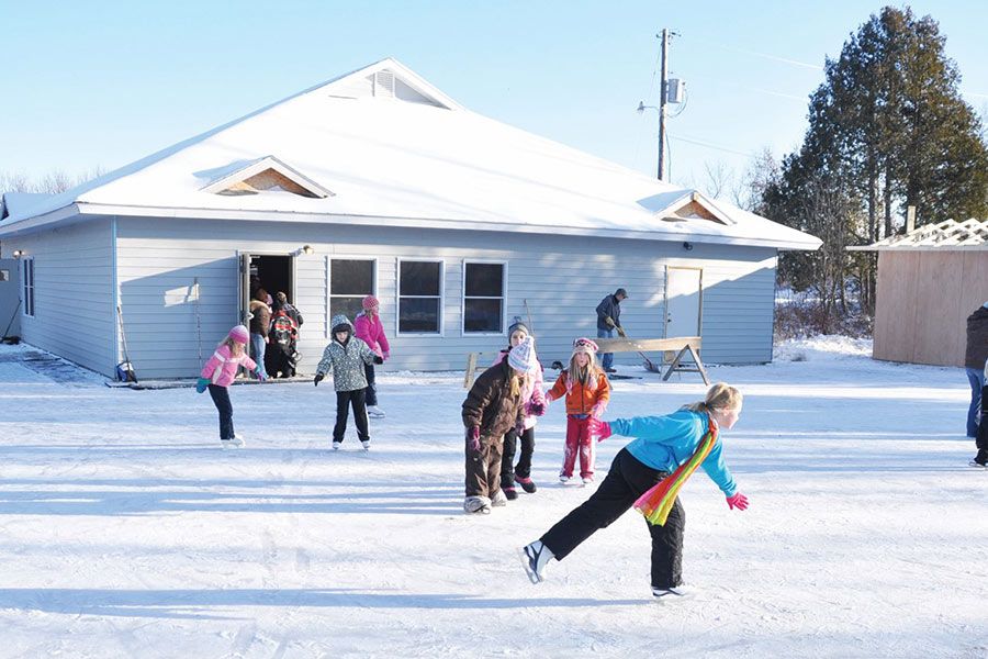 Image of a kids ice skating in front of the Ely Recreation Center