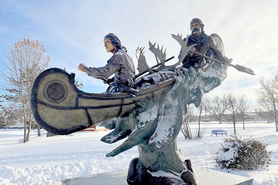 Image of a sculpture located in a park of people paddling a canoe